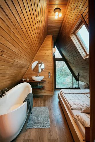 a bathroom with a bed and a tub and a sink at Valdo Cabin in Sadu