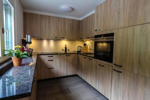 a kitchen with wooden cabinets and a black counter top at Weiherhof in Wildhaus