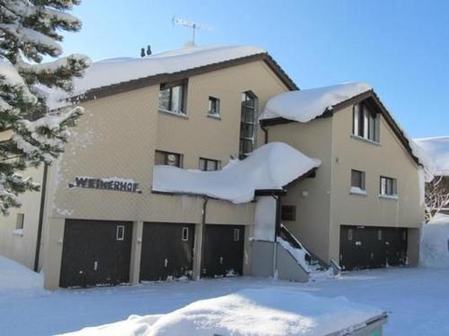 a building covered in snow with snow covered garage at Weiherhof in Wildhaus