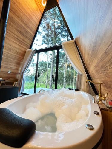 a large bath tub in a room with a window at Chalé Araucárias Cambará do Sul in Cambara do Sul
