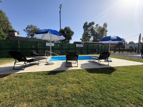 two chairs and two umbrellas next to a pool at Complejo San San Apto 201 in San Luis