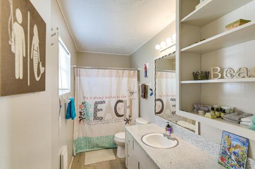 a bathroom with a sink and a toilet and a mirror at Ocean Views Second-Row Surfside Beach House in Surfside Beach