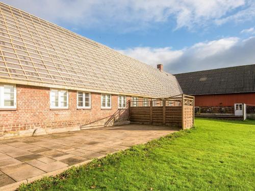 Emmerlev4 star holiday home in Højer的砖屋,前面设有大露台