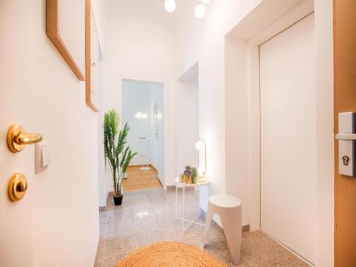 a white hallway with a table and a chair at Family-Friendly Apartment in Graz in Graz Ostbahnhof