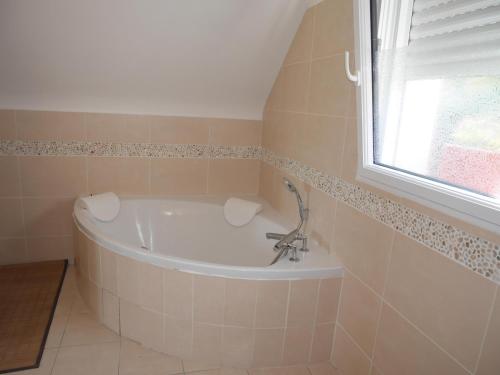 a bath tub in a bathroom with a window at Holiday home with partial sea view, Douarnenez in Tréboul