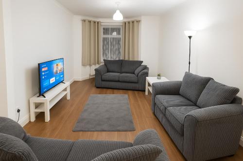 a living room with two couches and a flat screen tv at Modern 4 bedroom house in Belvedere in Erith