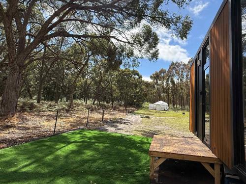 um banco de madeira sentado do lado de fora de uma casa em Bush Hideaway X at Tiny Away em Glenroy