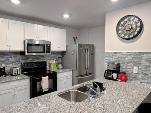 a kitchen with a sink and a refrigerator at Modern Comfort in Des Moines