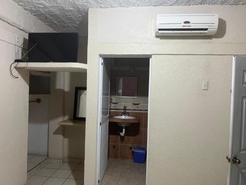 a room with a bathroom with a sink and a heater at Hotel Diana cazadora in Zihuatanejo