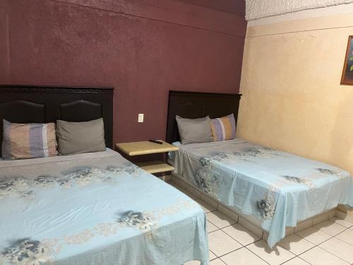 two beds sitting next to each other in a room at Hotel Diana cazadora in Zihuatanejo