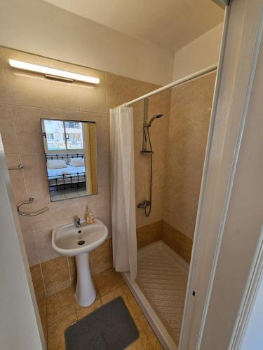 a bathroom with a sink and a shower at Front pool garden apartment in Paphos