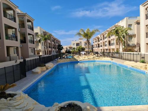 帕福斯Front pool garden apartment的两个公寓大楼中间的一个大型游泳池