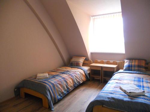 2 camas individuales en una habitación con ventana en Vētras en Rude