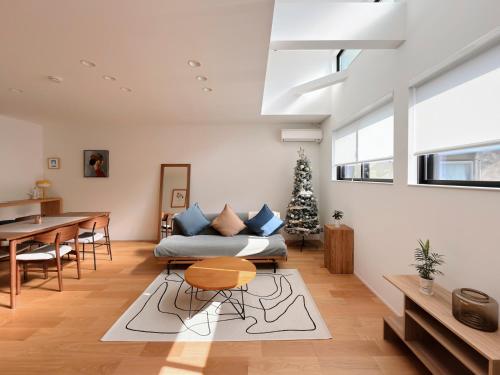 a living room with a couch and a christmas tree at USJ 梅田 大阪城へ直通 駐車場付きモダン一軒家 JR弁天町駅3分 LIRI Aoi in Osaka