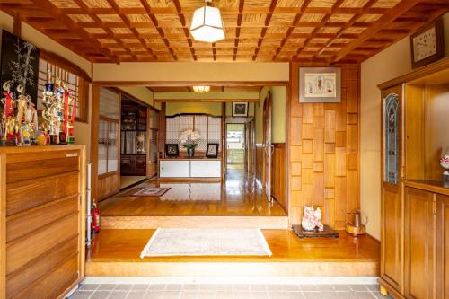 a living room with wood paneling and a hallway at 岐阜羽島の隠れ家 古民家cocone in Hashima