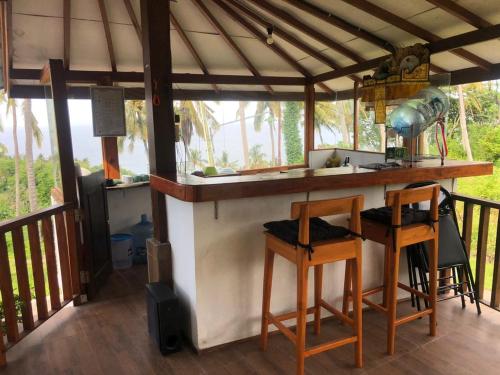 Eine Küche mit zwei Barhockern und einer Bar auf einer Veranda in der Unterkunft Villa RR Senggigi in Senggigi 