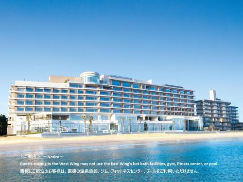 a large building on the beach next to the water at Karatsu Seaside Hotel in Karatsu