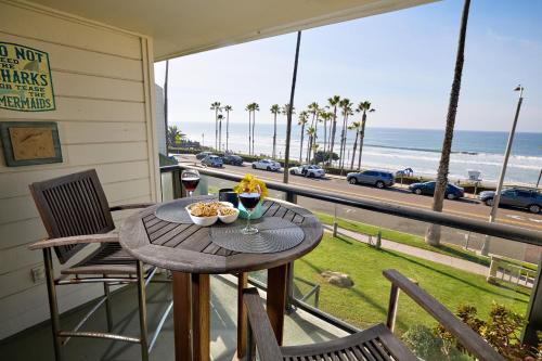 a table on a balcony with a view of the beach at 152-4 Coastal Luxury with Panoramic Ocean View in Oceanside