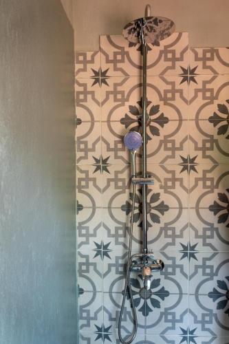 a bathroom with a tile wall with a shower at Zelenaiplava dormis in Merlo