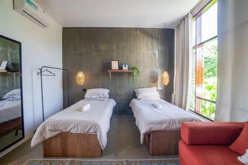 ein Zimmer mit 2 Betten und einem Sofa in einem Zimmer in der Unterkunft CIELO Siargao in General Luna
