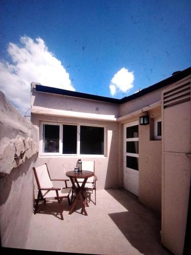 a patio with a table and a chair on a house at Lajas del Parque in Tandil