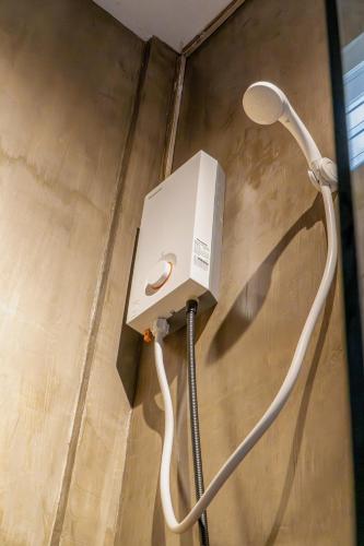 a shower with a white hose attached to a wall at CIELO Siargao in General Luna