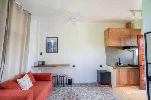 ein Wohnzimmer mit Sofa und eine Küche in der Unterkunft CIELO Siargao in General Luna