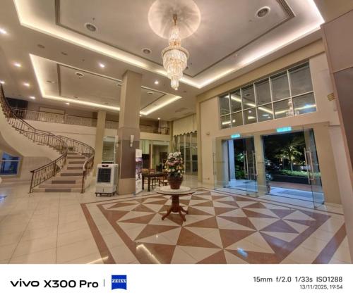 a lobby with a staircase and a table in a building at The Jerai Hotel Sungai Petani in Sungai Petani
