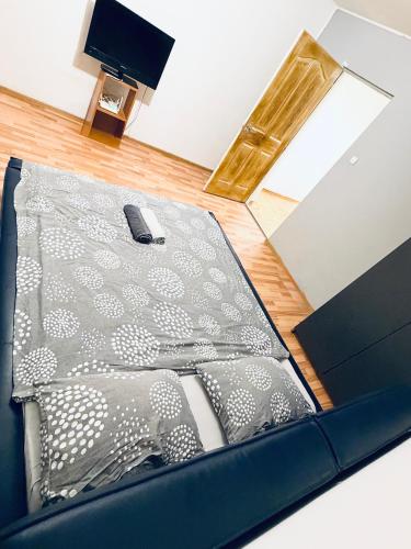 Una cama con una manta y un mando a distancia. en Take Ionescu Center Studio Apartment, en Timisoara