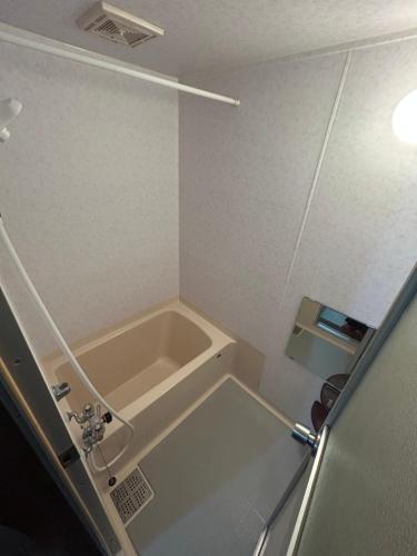 een kleine badkamer met een wastafel en een bad bij 青山ハウス in Otaru