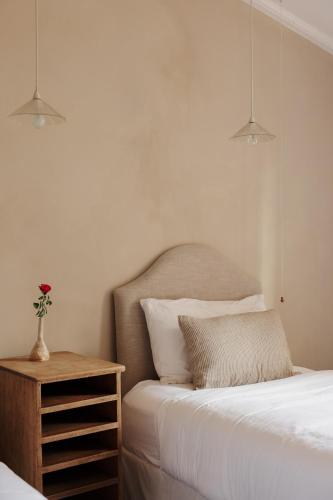 a bedroom with a bed and a vase with a flower on a table at The Old Clarence Brewery in Maclean