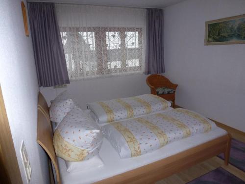 ein Schlafzimmer mit einem Bett mit Kissen und einem Fenster in der Unterkunft Ferienwohnung Koch in Bayerisch Eisenstein