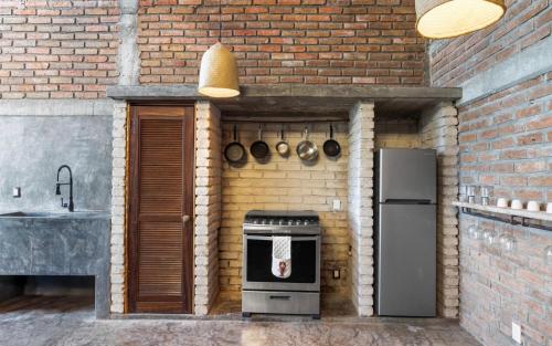 a brick kitchen with a sink and a stove at Summer Salt Beach Casita in Punta Mita