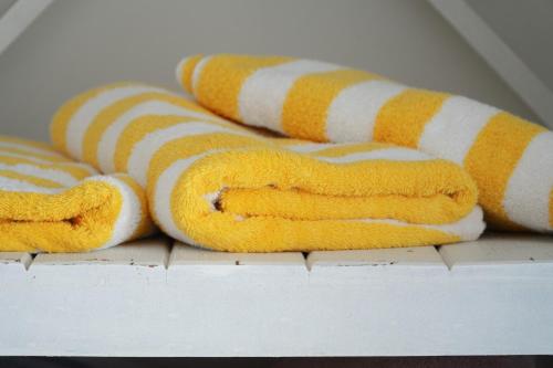 eine Gruppe gelber und weißer Handtücher auf einem Tisch in der Unterkunft Casa da Imperatriz in Ilhabela