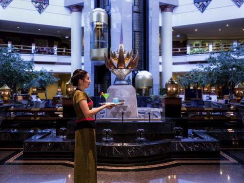a woman standing in front of a fountain in a building at Pullman Khon Kaen Raja Orchid in Khon Kaen