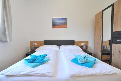 a bedroom with a bed with blue towels on it at Apartments with parking space Seline, Paklenica - 22077 in Starigrad-Paklenica