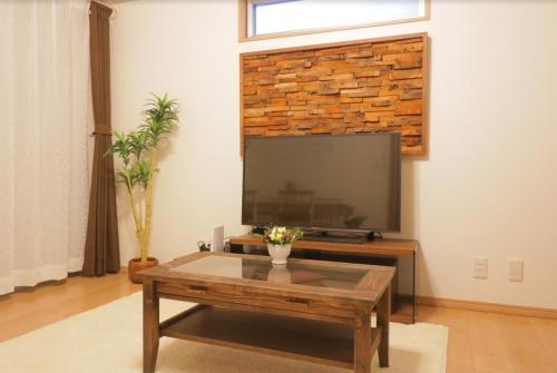 a living room with a tv and a coffee table at Cozy enjoyment hotel no.29 in Kyoto