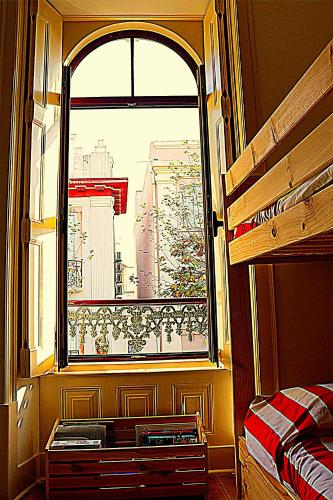 a bedroom with a window with a view of a city at Liberdade 75 Family Holiday House in Figueira da Foz