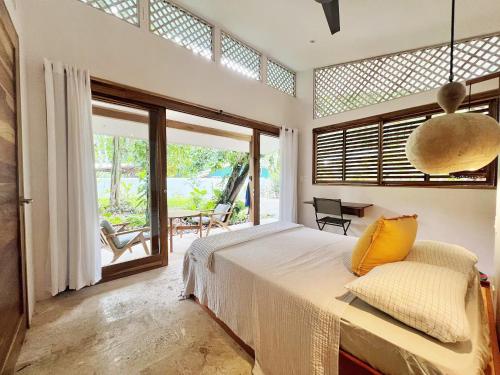une chambre avec un grand lit et une grande fenêtre dans l'établissement Villas Guaitil Cozy Jungle Hideaway in Playa Chiquita, à Puerto Viejo