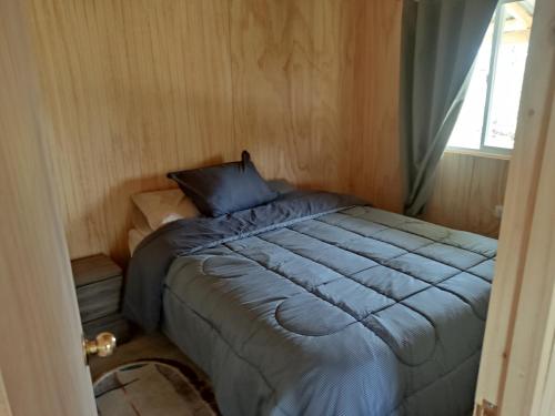 a bed in a small room with a window at Princesa in Puerto Montt