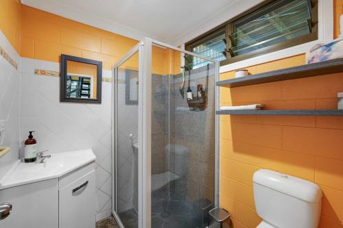 a bathroom with a shower and a toilet and a sink at Edge Hill Apartment under Queenslander w Pool in Edge Hill