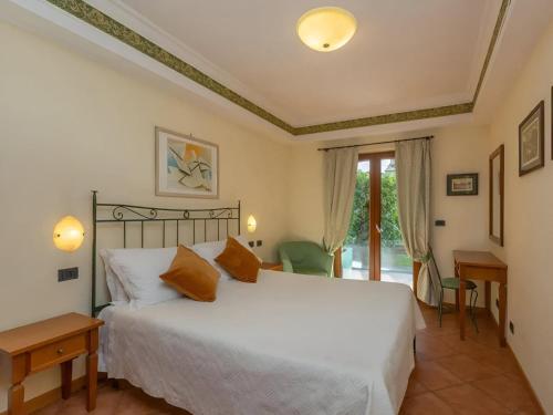 une chambre avec un grand lit blanc et une fenêtre dans l'établissement Apartment in Roma by Marco Simone Golf, à Marco Simone