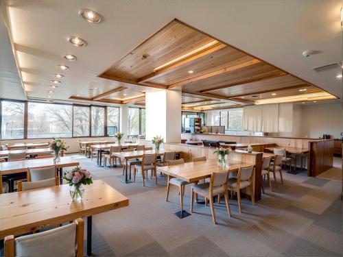 Un comedor con mesas y sillas de madera. en Wonderwall美好境界 日本藏王館, en Yamagata