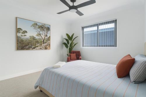 a white bedroom with a bed and a window at Peaceful Homestead Getaway - BBQ, Backyard & Farm Life in Toronto