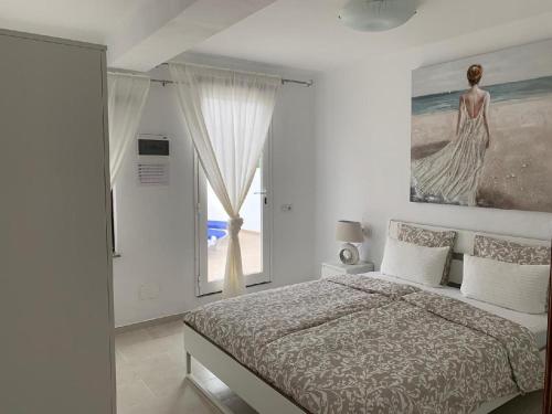a bedroom with a bed and a large window at Ferienwohnung Luna in Charco del Palo