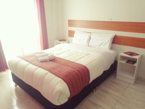 a bedroom with a large bed with a red and white blanket at Belys inn in Cusco