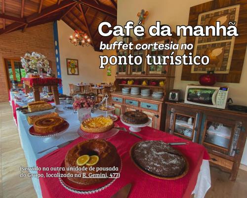 Pousada Viviê CENTRAL في مونتي فيردي: طاولة مليئة بالكعك والفطائر على طاولة