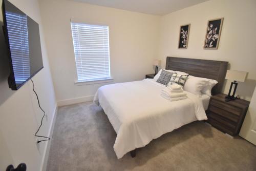 une chambre avec un lit et une télévision à écran plat dans l'établissement Bright, charming, modern townhouse in Winder, à Winder
