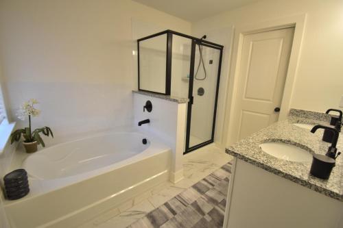 une salle de bain blanche avec une baignoire et un lavabo dans l'établissement Bright, charming, modern townhouse in Winder, à Winder