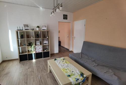 ein Wohnzimmer mit Sofa und Tisch in der Unterkunft Gemütliche Ferienwohnung in Herrensohr mit Garten, Grill und Terrasse in Neuweiler